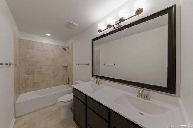 full bathroom featuring toilet, tile patterned floors, vanity, a textured ceiling, and tiled shower / bath combo