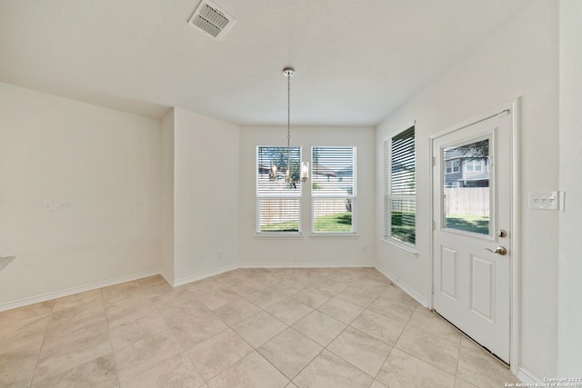 unfurnished dining area featuring light tile patterned floors and an inviting chandelier