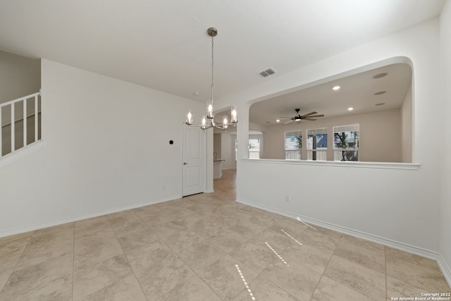 unfurnished room featuring ceiling fan with notable chandelier