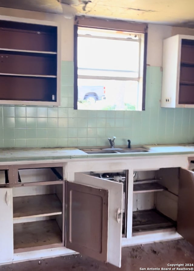 kitchen featuring sink, wine cooler, and backsplash