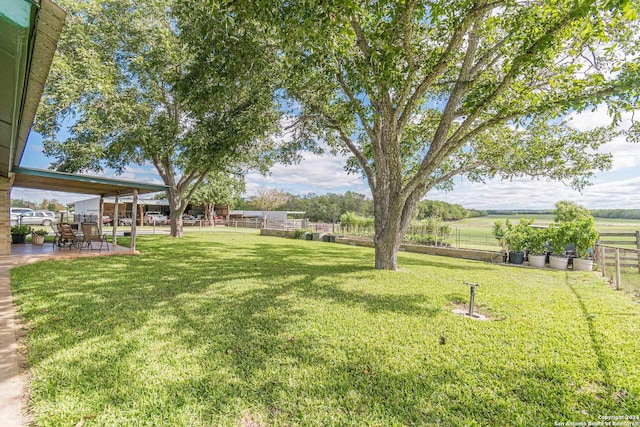 view of yard with a rural view and a patio area