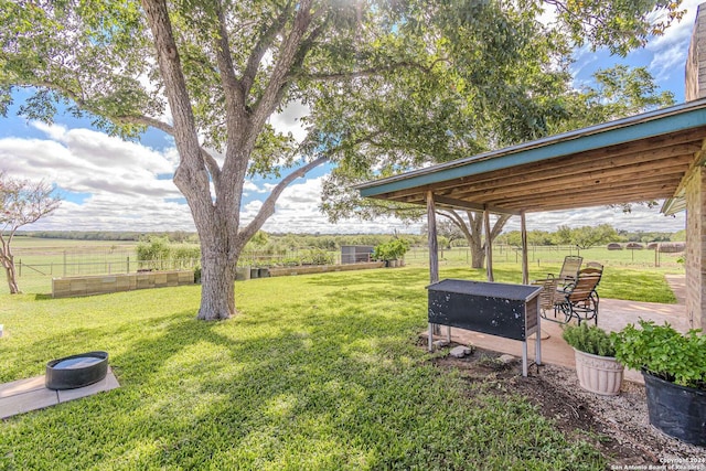 view of yard with a rural view and a patio area