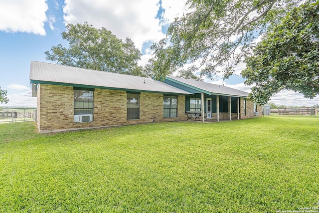 rear view of property featuring a yard