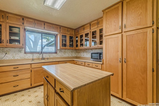 kitchen featuring a textured ceiling, sink, and a kitchen island