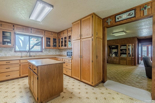 kitchen with a textured ceiling, sink, and a center island