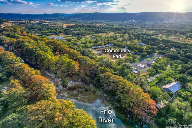 aerial view at dusk featuring a water and mountain view