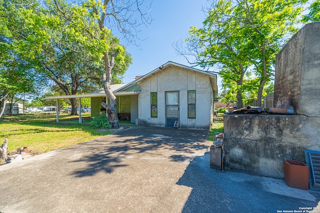 view of front of house featuring a front lawn and a carport