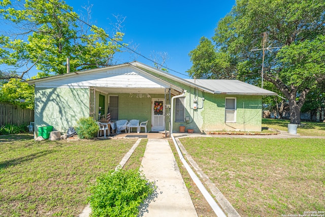 bungalow-style house featuring a front lawn and a patio