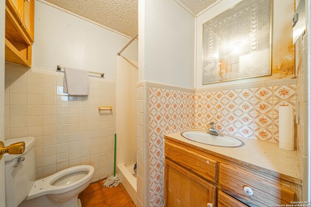 bathroom with tile walls, a textured ceiling, walk in shower, vanity, and toilet