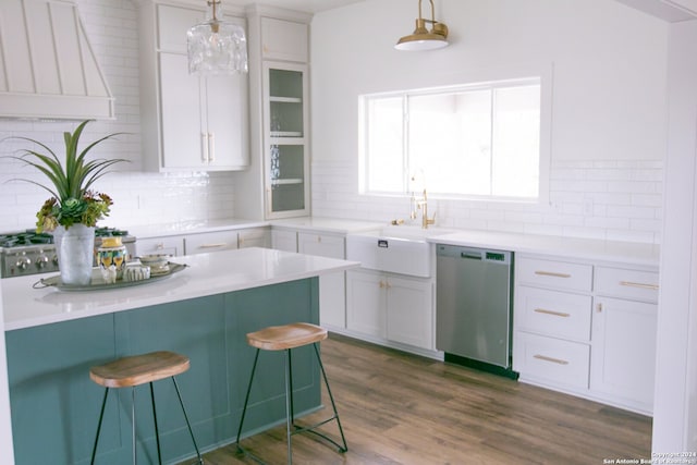 kitchen with white cabinets, premium range hood, decorative light fixtures, and dishwasher