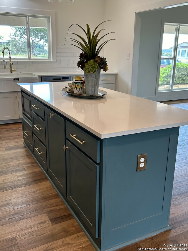 kitchen featuring tasteful backsplash, a center island, sink, and hardwood / wood-style flooring