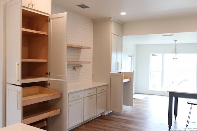 kitchen with decorative light fixtures, dark hardwood / wood-style flooring, decorative backsplash, and white cabinetry