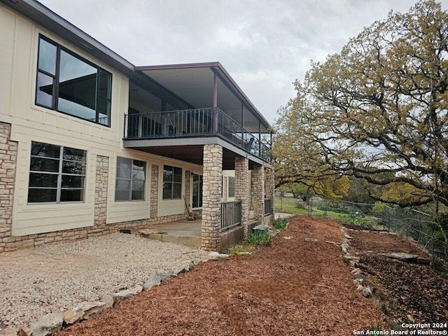 back of house with a balcony and a patio area