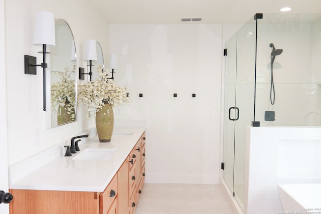 bathroom featuring a shower with door and vanity