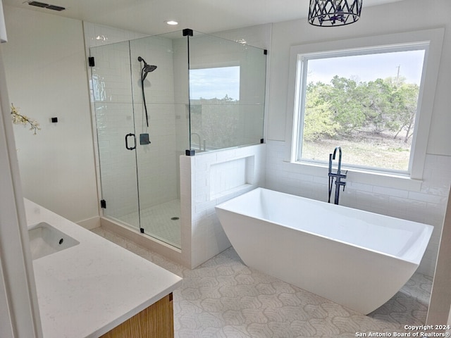 bathroom featuring shower with separate bathtub, a wealth of natural light, and vanity