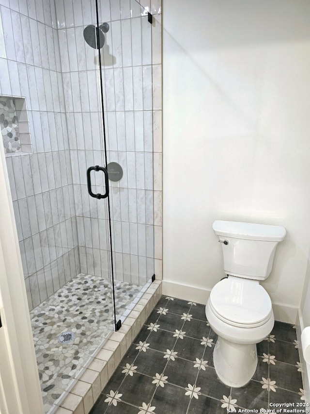 bathroom featuring walk in shower and toilet