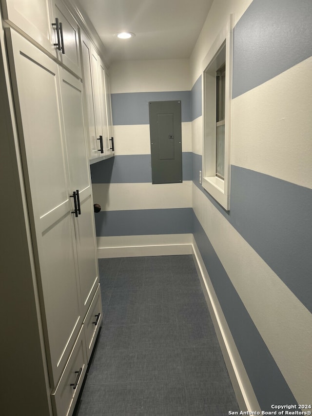 corridor featuring electric panel and dark carpet