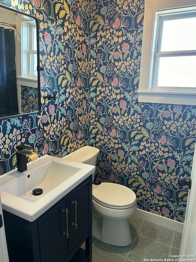 bathroom with tile patterned flooring, vanity, and toilet