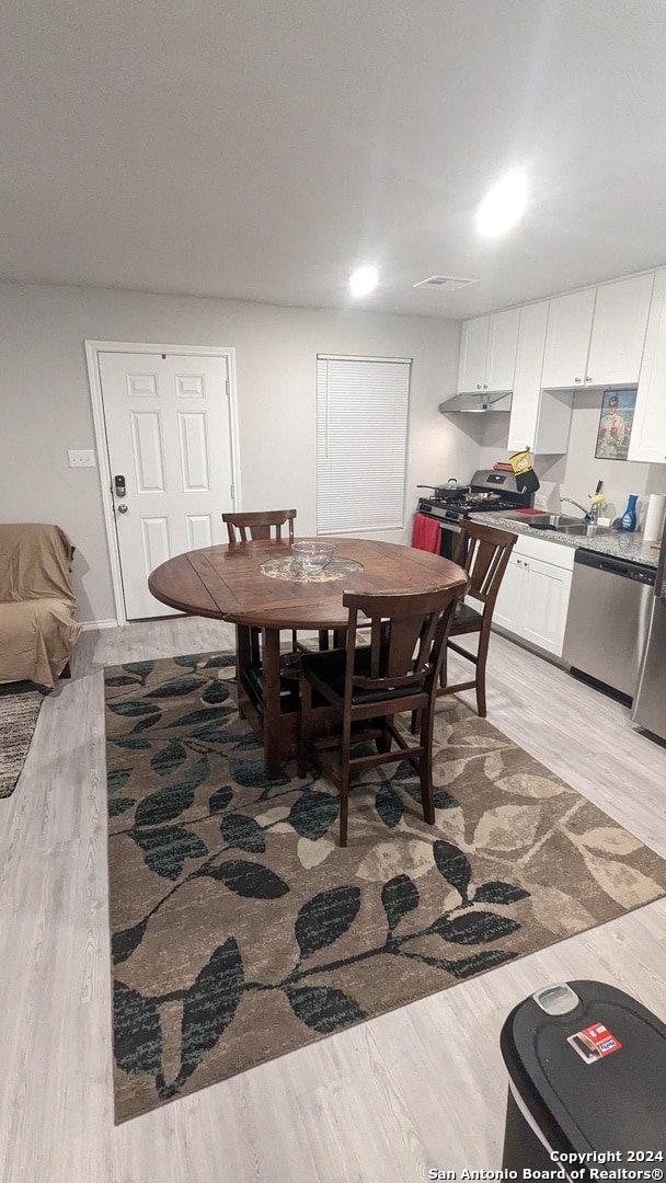 dining room featuring light wood-type flooring and sink