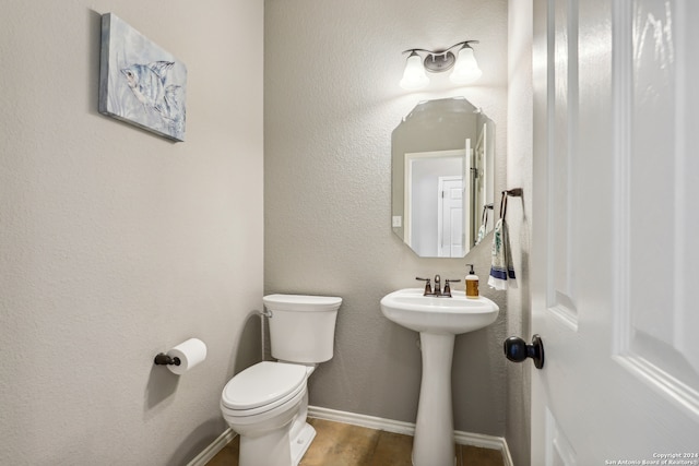 bathroom featuring wood-type flooring and toilet