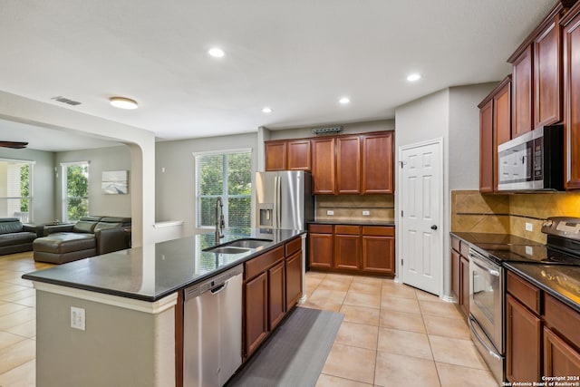 kitchen featuring a kitchen island with sink, stainless steel appliances, plenty of natural light, and sink