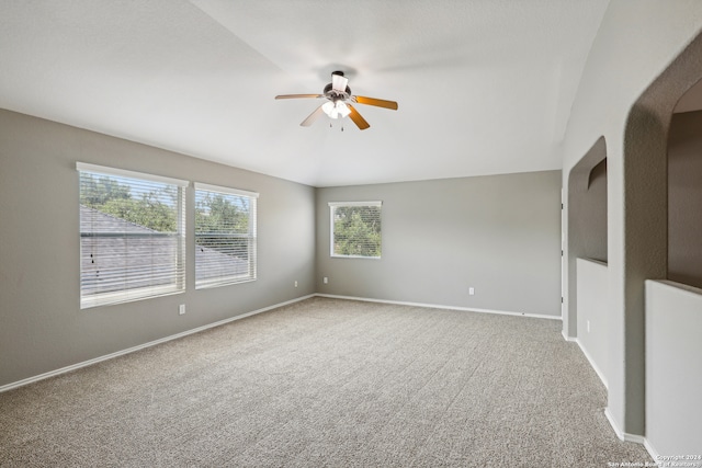 unfurnished room with ceiling fan, lofted ceiling, and carpet