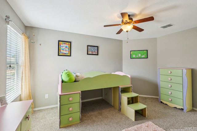 carpeted bedroom with multiple windows and ceiling fan