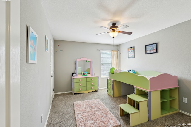 bedroom with ceiling fan, carpet flooring, and a textured ceiling