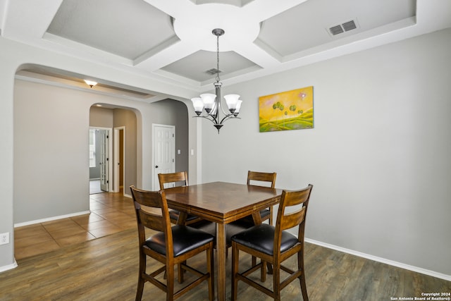 dining area featuring beamed ceiling, a chandelier, coffered ceiling, and dark wood-type flooring