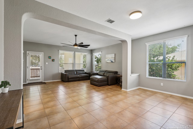 unfurnished living room featuring a wealth of natural light, ceiling fan, and light tile patterned floors