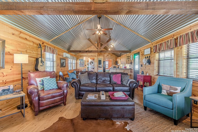 living room featuring lofted ceiling with beams, wood walls, ceiling fan, and hardwood / wood-style flooring