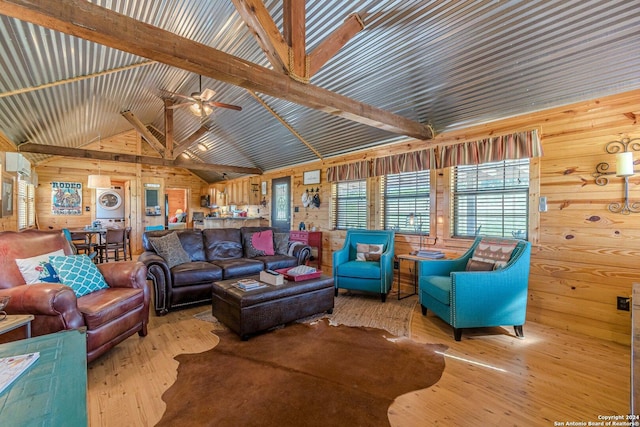 117 Hawk Rd, Fredericksburg, TX 78624 - living area with lofted ceiling with beams, stacked washer / dryer, wood walls, ceiling fan, and hardwood / wood-style floors