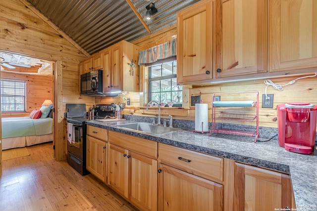 117 Hawk Rd, Fredericksburg, TX 78624 - kitchen with vaulted ceiling, a sink, black appliances, light wood finished floors, and wood walls