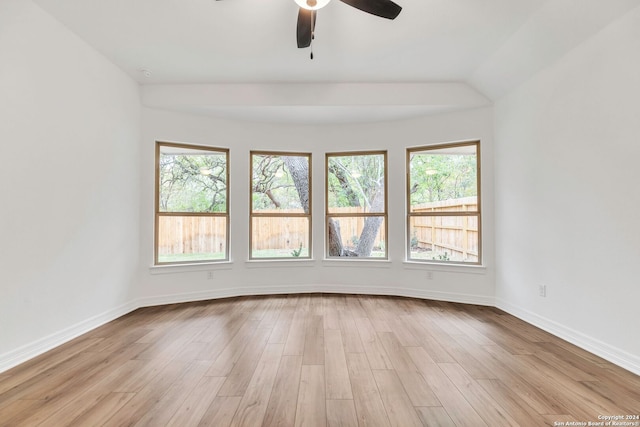 empty room with light hardwood / wood-style floors, vaulted ceiling, and ceiling fan