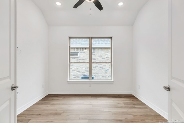 empty room with ceiling fan, light hardwood / wood-style floors, and vaulted ceiling