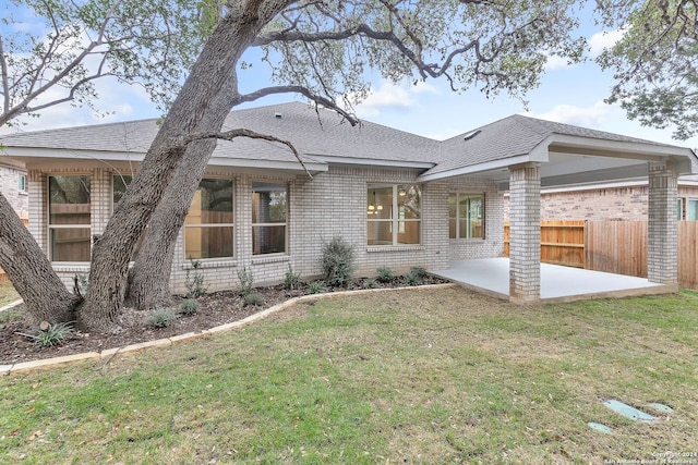 rear view of house with a lawn and a patio area