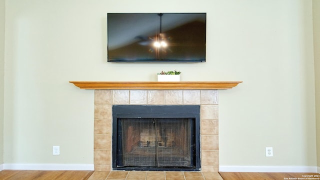 details featuring hardwood / wood-style floors and a tile fireplace