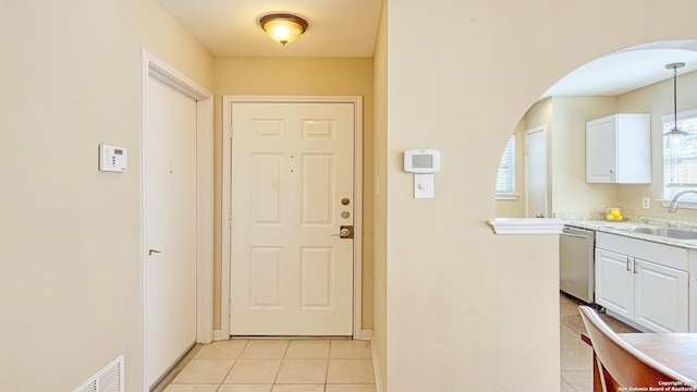 entryway with light tile patterned floors and sink