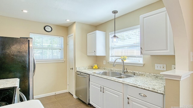 kitchen with appliances with stainless steel finishes, hanging light fixtures, sink, and white cabinets