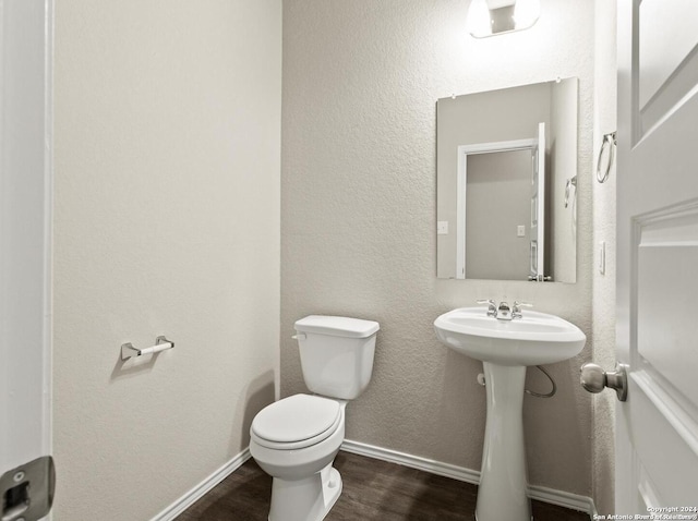 bathroom featuring wood-type flooring and toilet