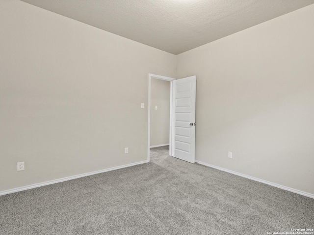 carpeted spare room with a textured ceiling