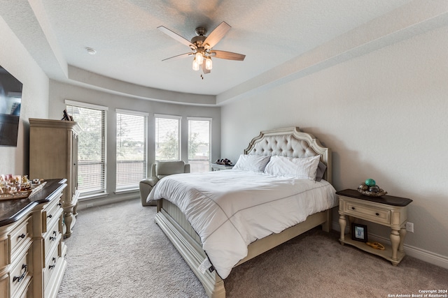 bedroom featuring a textured ceiling, ceiling fan, and light colored carpet