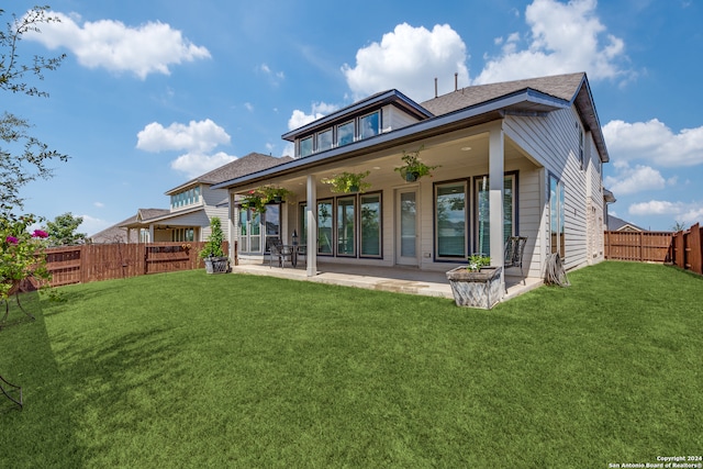 back of property featuring a yard, ceiling fan, and a patio area