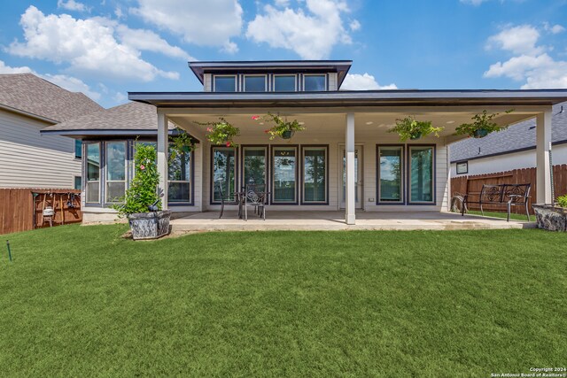 rear view of property with a patio and a yard