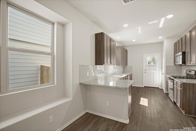 4951 Sandstone Way, San Antonio, TX 78222 - kitchen featuring stainless steel appliances, tasteful backsplash, dark wood-style flooring, light stone counters, and recessed lighting