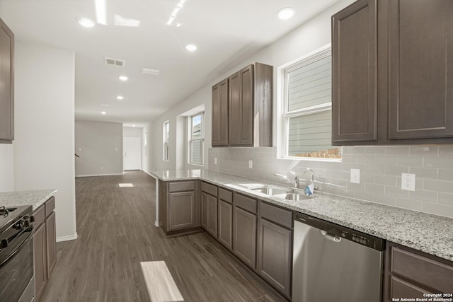 4951 Sandstone Way, San Antonio, TX 78222 - kitchen featuring stainless steel appliances, decorative backsplash, dark wood finished floors, light stone countertops, and open floor plan