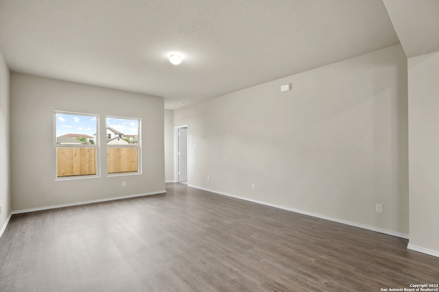 unfurnished room featuring a textured ceiling and dark hardwood / wood-style floors