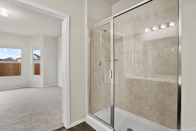 bathroom with a textured ceiling and a shower with door