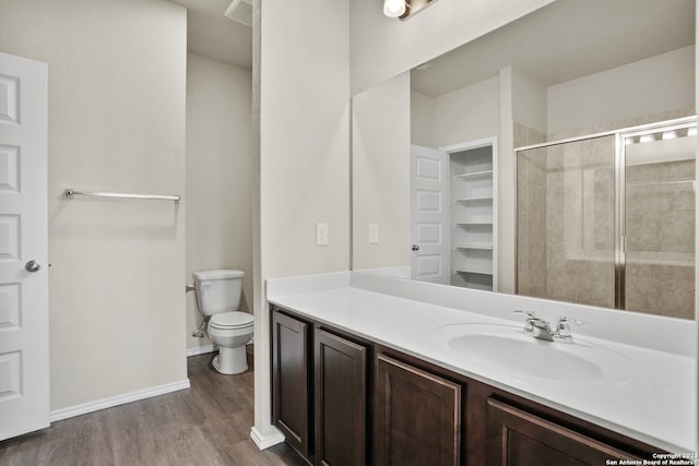 bathroom with an enclosed shower, hardwood / wood-style flooring, vanity, and toilet