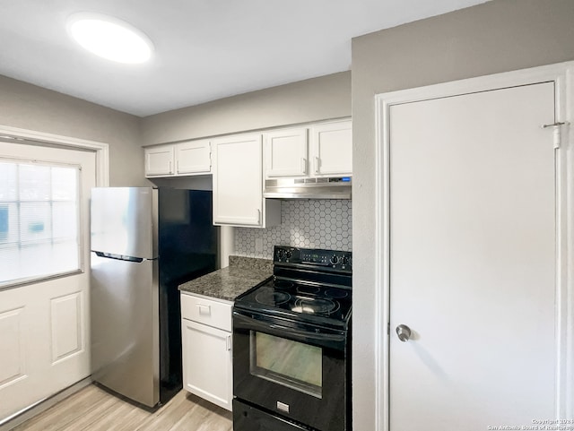 kitchen featuring white cabinets, light hardwood / wood-style flooring, dark stone counters, stainless steel refrigerator, and black range with electric cooktop